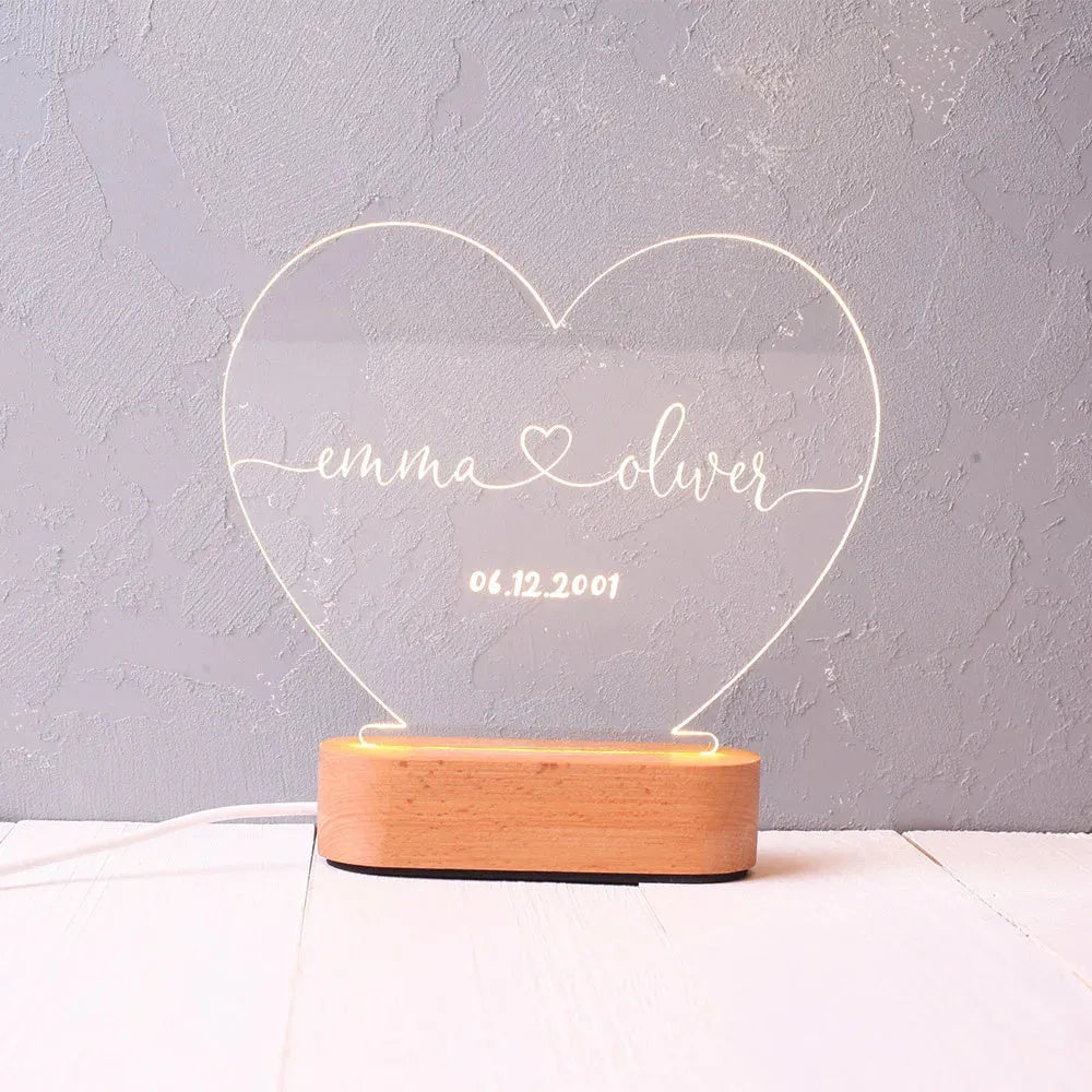 Custom engraved acrylic night light with names and date, illuminated by an LED base.