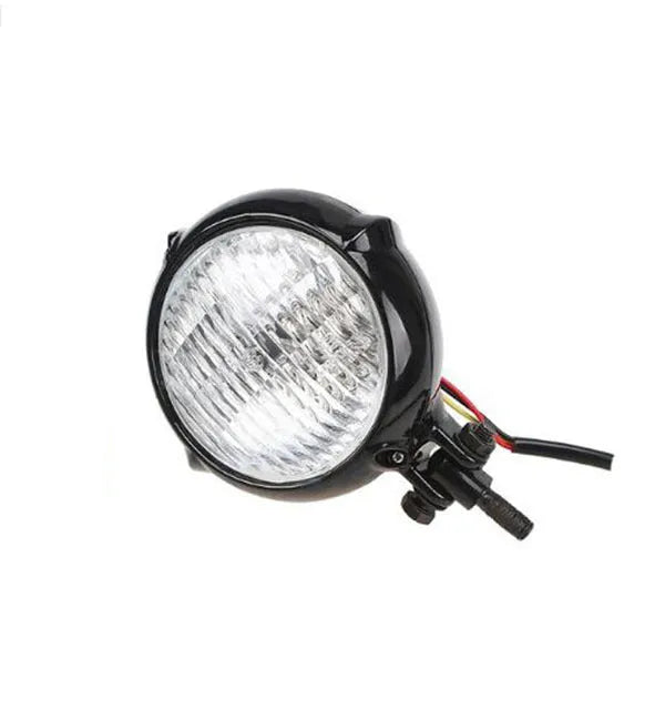 Black electroplated halogen headlight for Harley motorcycles showing 8cm diameter lens and cast aluminium housing.