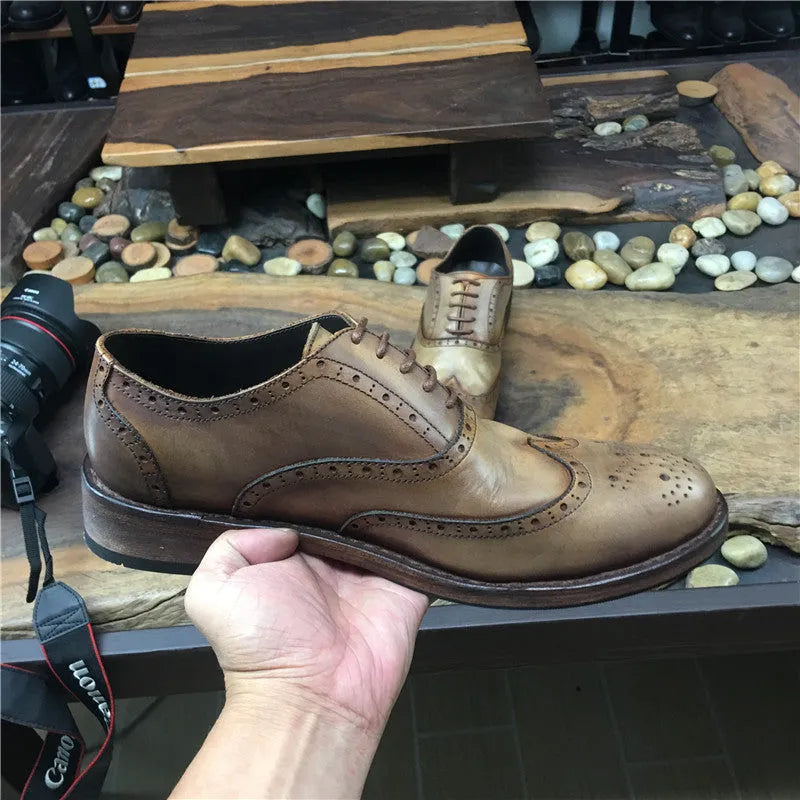 Light brown men's distressed leather lace-up shoes with engraved detailing and round toe on a neutral background.