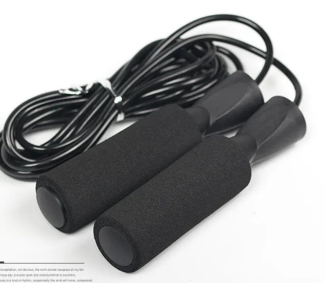 Adjustable jump rope with weighted black handles on a gym mat
