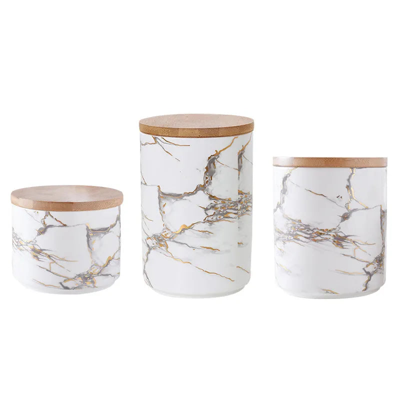 3 piece marbled ceramic jar set with wooden lids large medium and small on a countertop