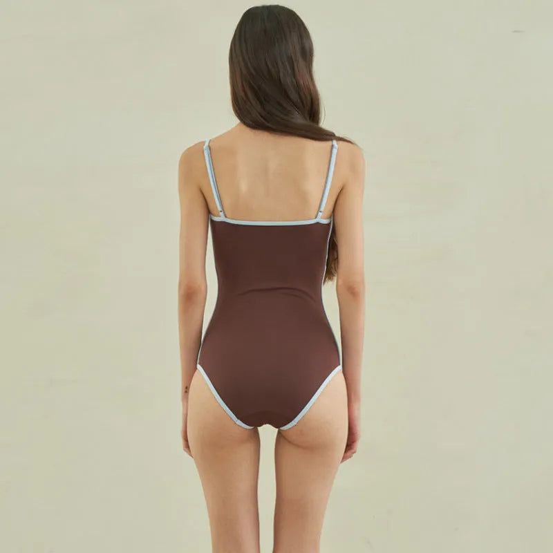 Brown women's triangle one-piece nylon swimsuit on a hanger.