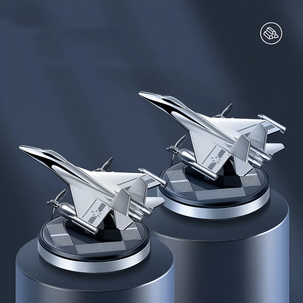 Silver solar-powered rotating fighter aircraft perfume ornament on a surface.