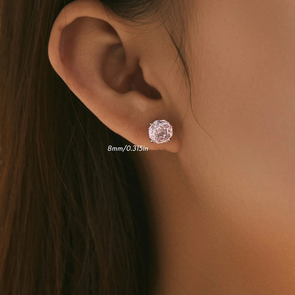 A pair of sterling silver stud earrings featuring a detailed rose flower design.
