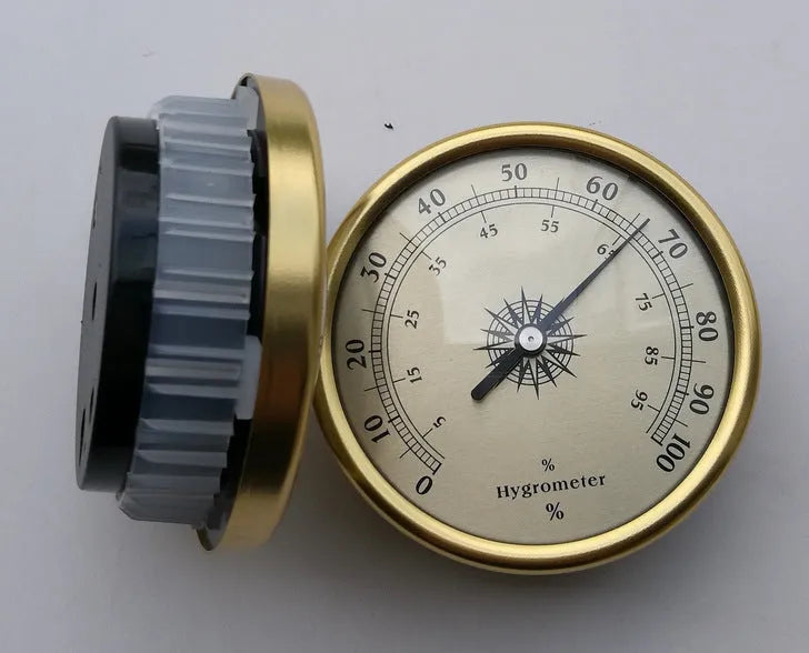 Analogue thermometer and hygrometer with aluminium dial on white background