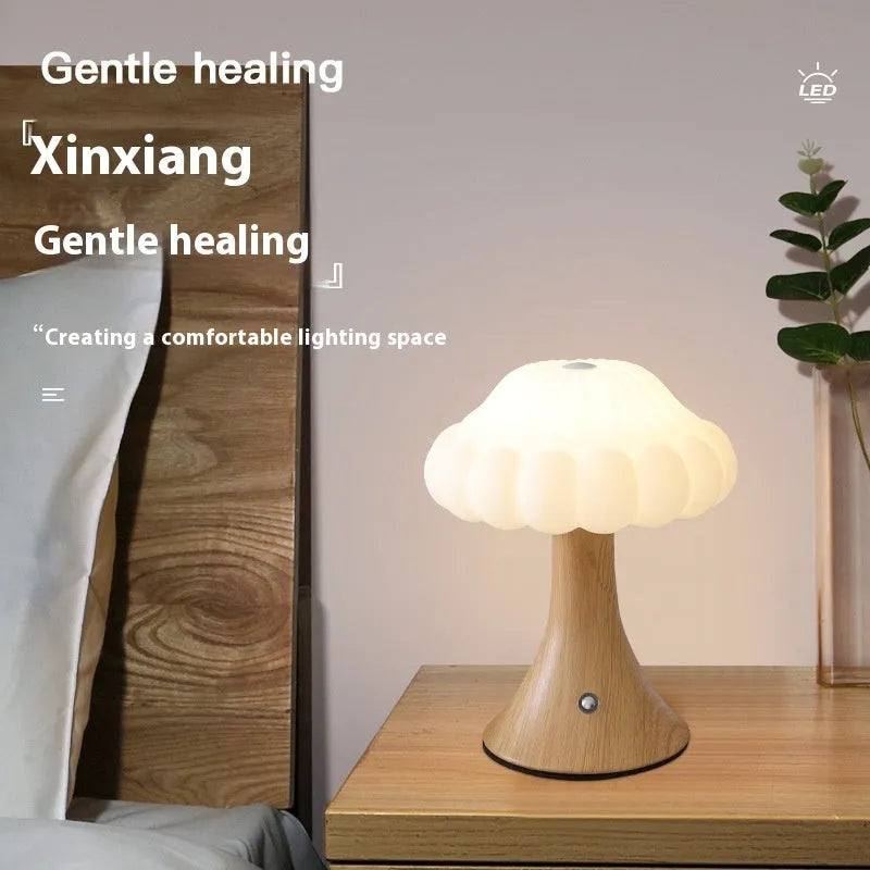 Small touch-controlled mushroom night lamp in wood grain colour on a table.