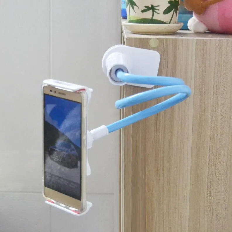 Black bedside phone holder with long arm extended, holding a mobile phone at an angle on a wooden table.