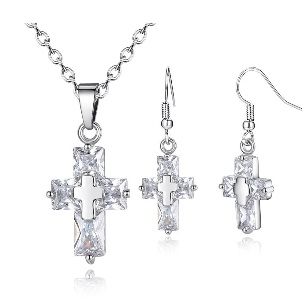 Gold cross pendant and matching stud earrings set on a light background showing compact 1.2 x 2.2 cm pendant and 3.3 x 1.2 cm studs