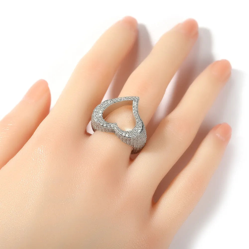 Gold copper ring with hollow heart cut-out and zircon stone on finger