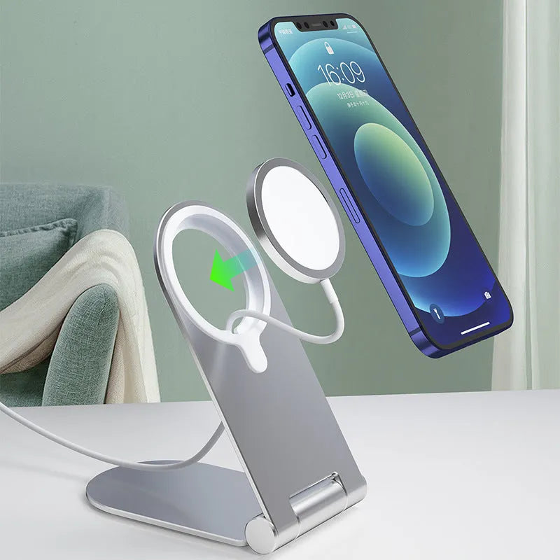 Silver aluminium alloy and plastic magnetic phone bracket for iPhone 12 on a desk.