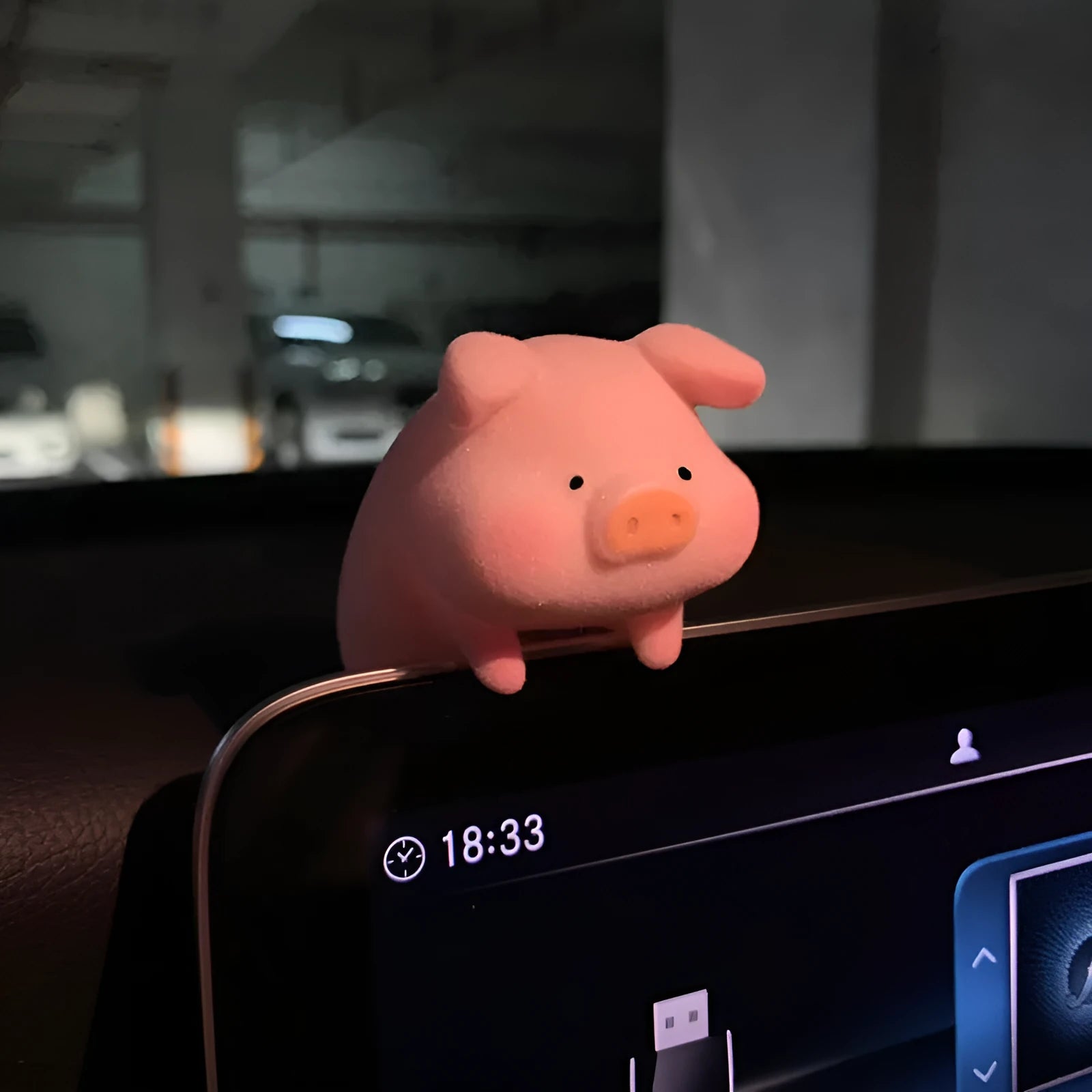 A cute cartoon pig resin figurine car decoration accessory on a dashboard.