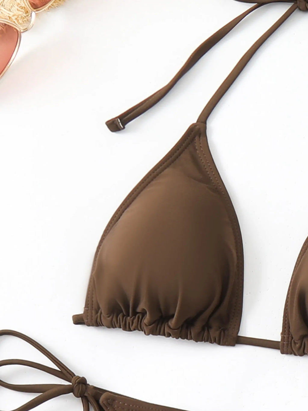 Brown women's three-piece swimsuit set comprising a bra, shorts, and blouse on a plain background.