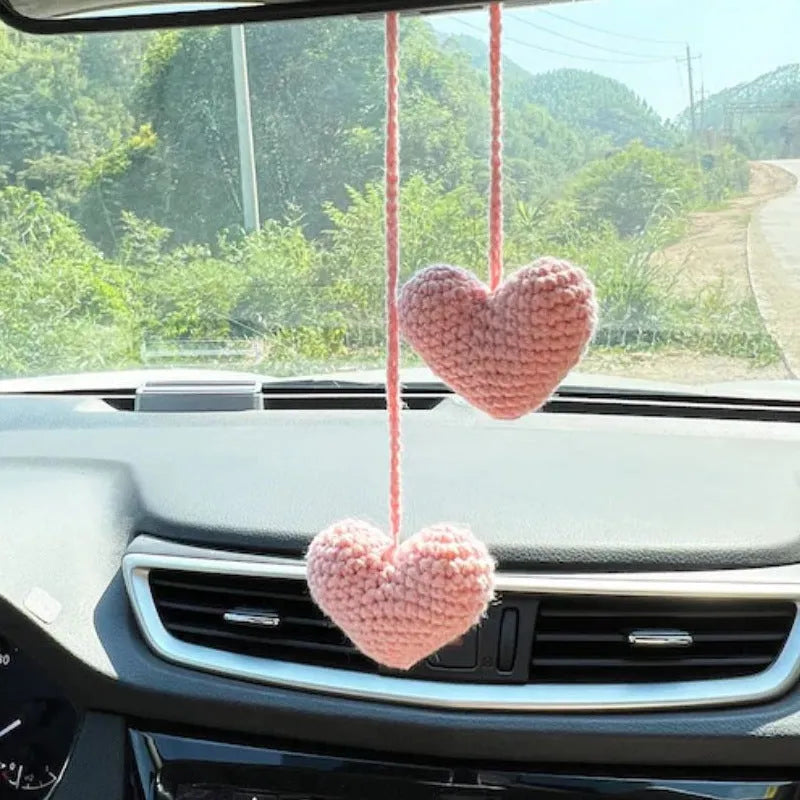 Green and white knitted wool car plant ornament hanging from a rope