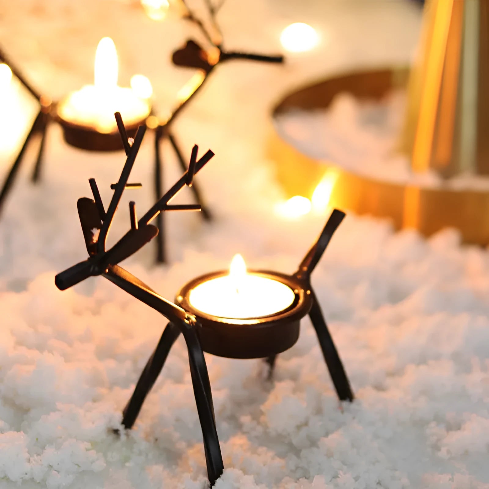 Black iron Christmas deer candlestick holder with elk silhouette on a table.