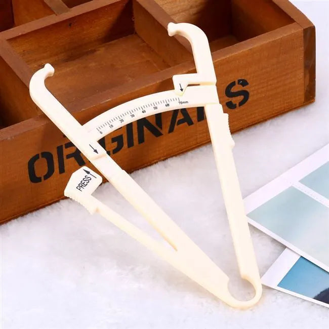 Acrylic skin fold caliper body fat measuring instrument showing scale and measurement jaws