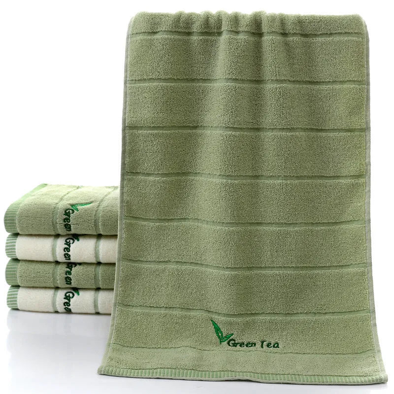 Pure cotton 32 strand embroidered face washing towel in green, 34x74cm, folded on a surface