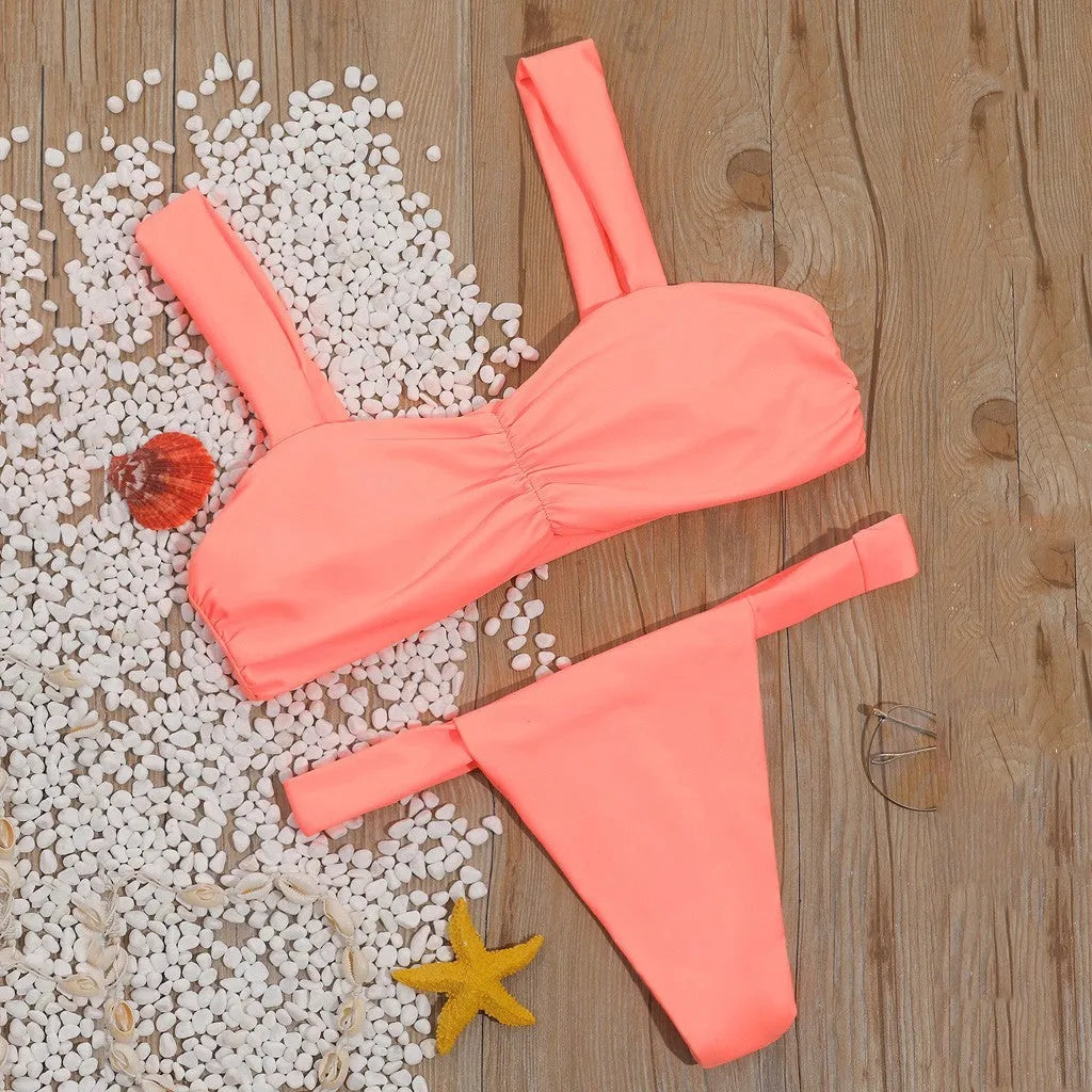 Solid colour orange split bikini swimsuit with high-cut legs on a model by the pool