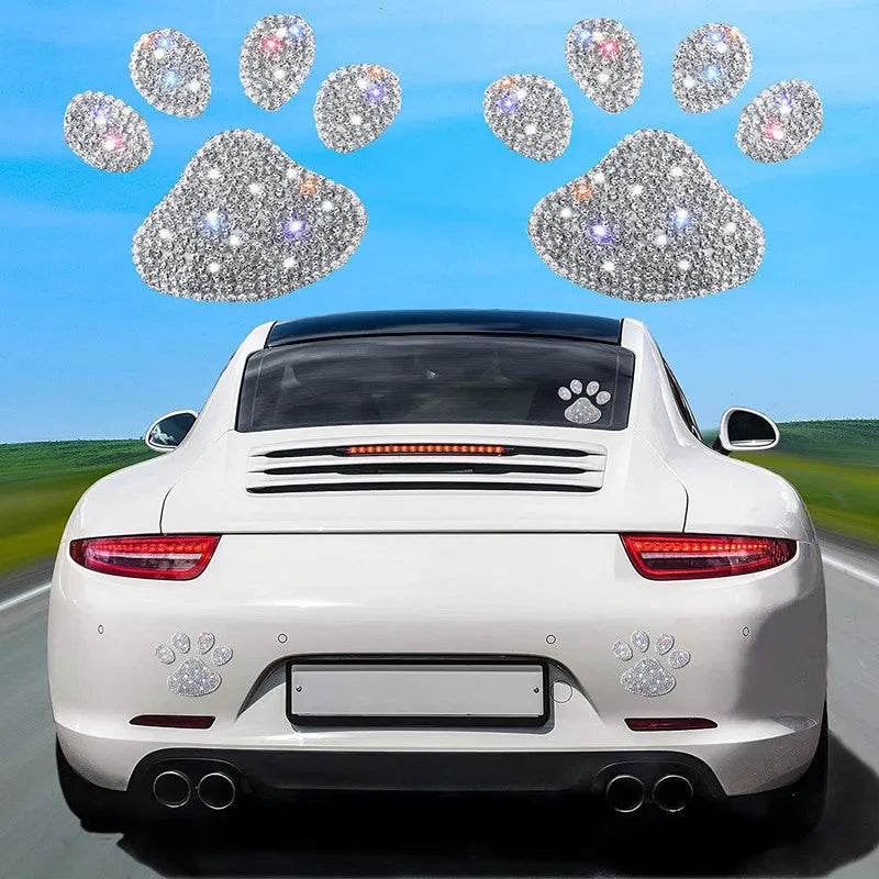 Close-up of a diamond-encrusted glass car sticker in a bear paw design on a car window.