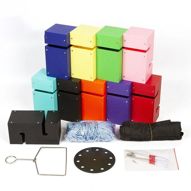 Outdoor team building game set showing coloured ABS plastic tower blocks, pull ropes, and a central hook frame on grass.