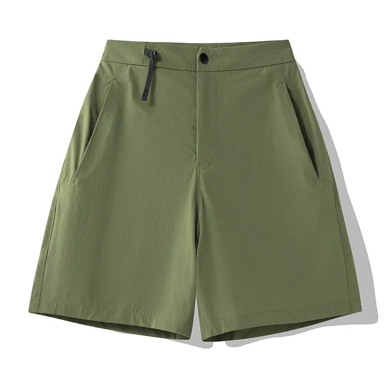Man wearing khaki athletic shorts with four-way stretch, demonstrating movement for running or climbing.