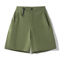 Man wearing khaki athletic shorts with four-way stretch, demonstrating movement for running or climbing.