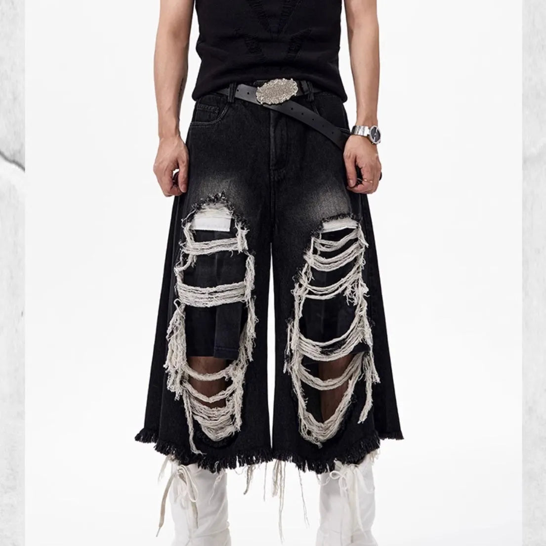 Black wide leg cropped jeans with distressed patch details on the legs, showing a mid-high waist.