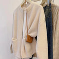 Beige viscose knit sweater coat cardigan with long sleeves laid flat.