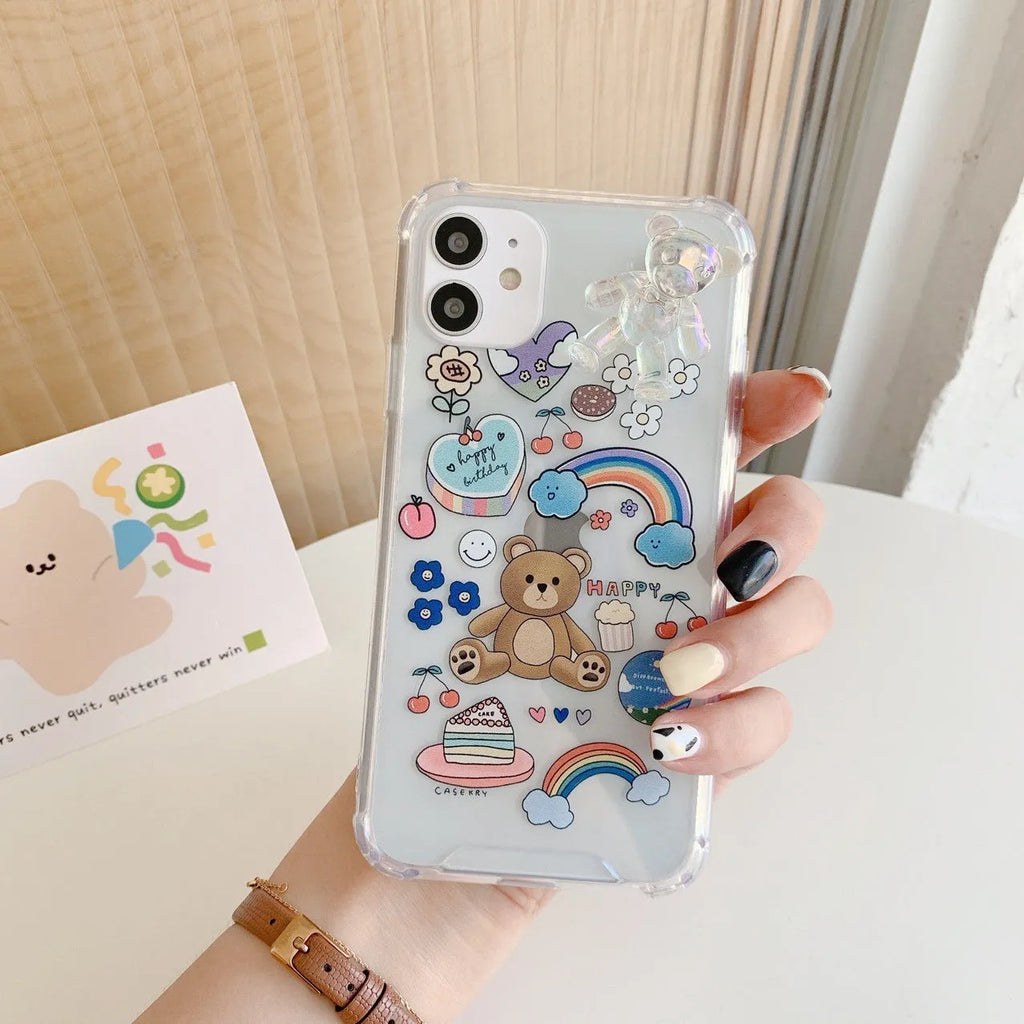 White iPhone case with a cartoon bear design and a connected silver bear pendant on a chain.
