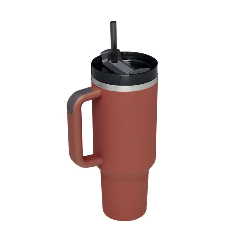 40 oz stainless steel insulated tumbler with a black handle, straw, and grey lid on a wooden table