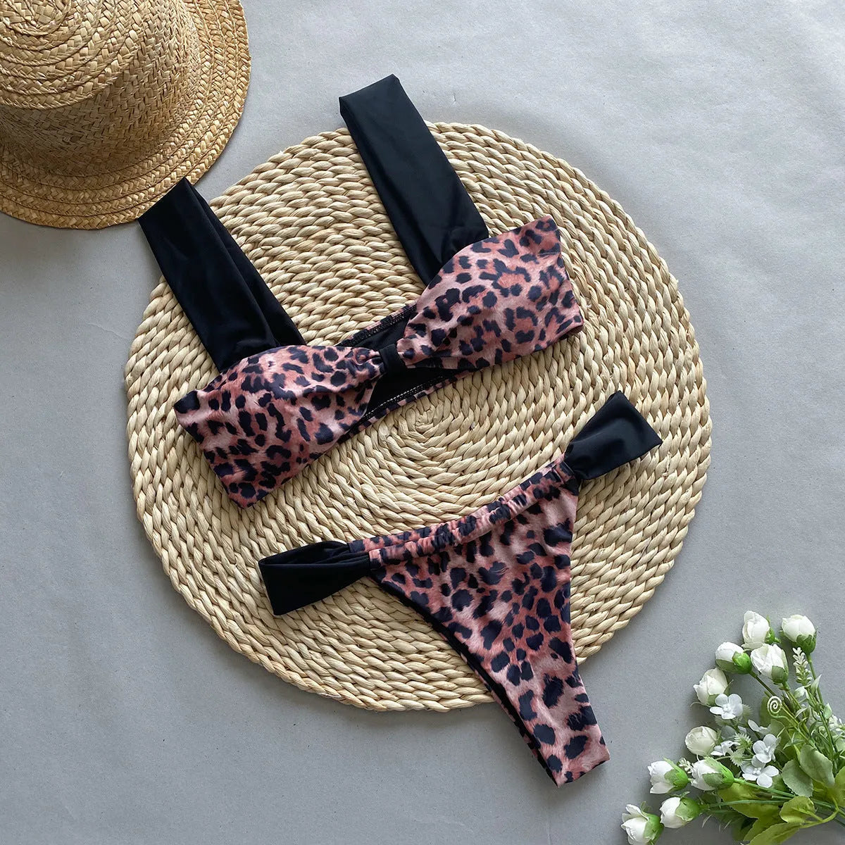 Women's black and leopard print tube top bikini set laid flat, showing the sleeveless top and briefs.