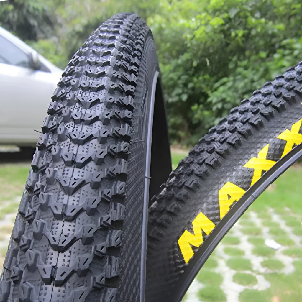 Ultralight mountain bike tyre with black tread and optional white sidewall, shown in sizes 26, 27.5 and 29 inch.