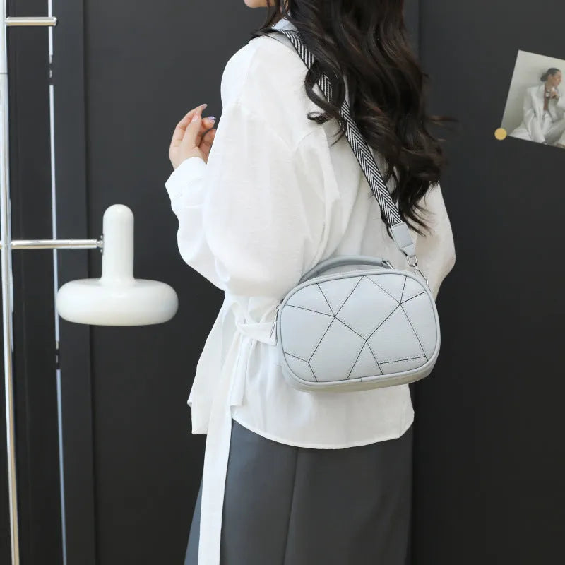 Round PU leather crossbody bag with patchwork design showing decorative stitching