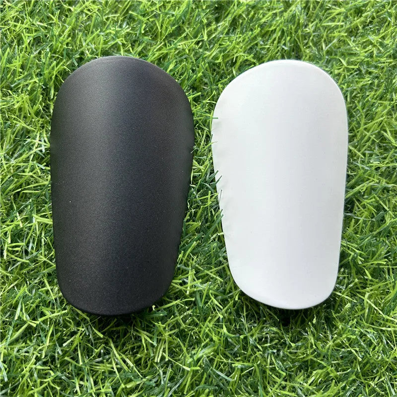 Extra small mini football shin guards in black and white, measuring 8x5cm