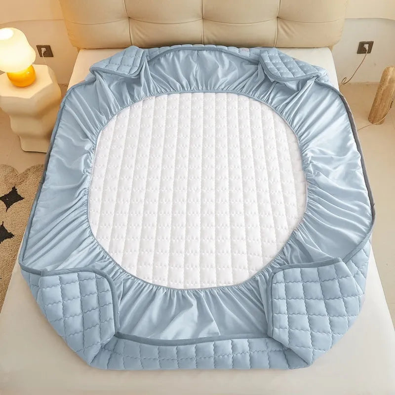 Class A waterproof fitted sheet in washed cotton, shown in a neutral colour on a bed.