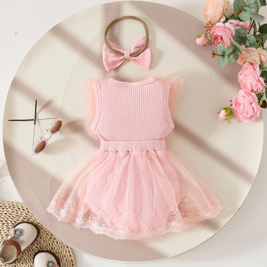 Baby girl in white triangle jumpsuit leotard with sweet bow hair band