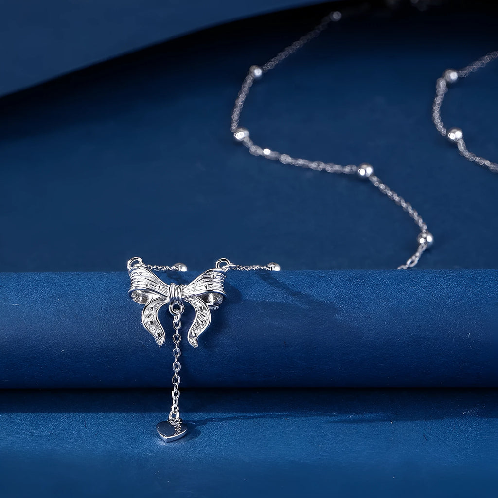 S925 sterling silver necklace with heart and bow pendant on an adjustable O-ring chain.