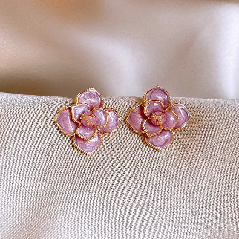 Gold plated purple oil-spot glaze 3D flower stud earrings with surgical steel posts on a white background.