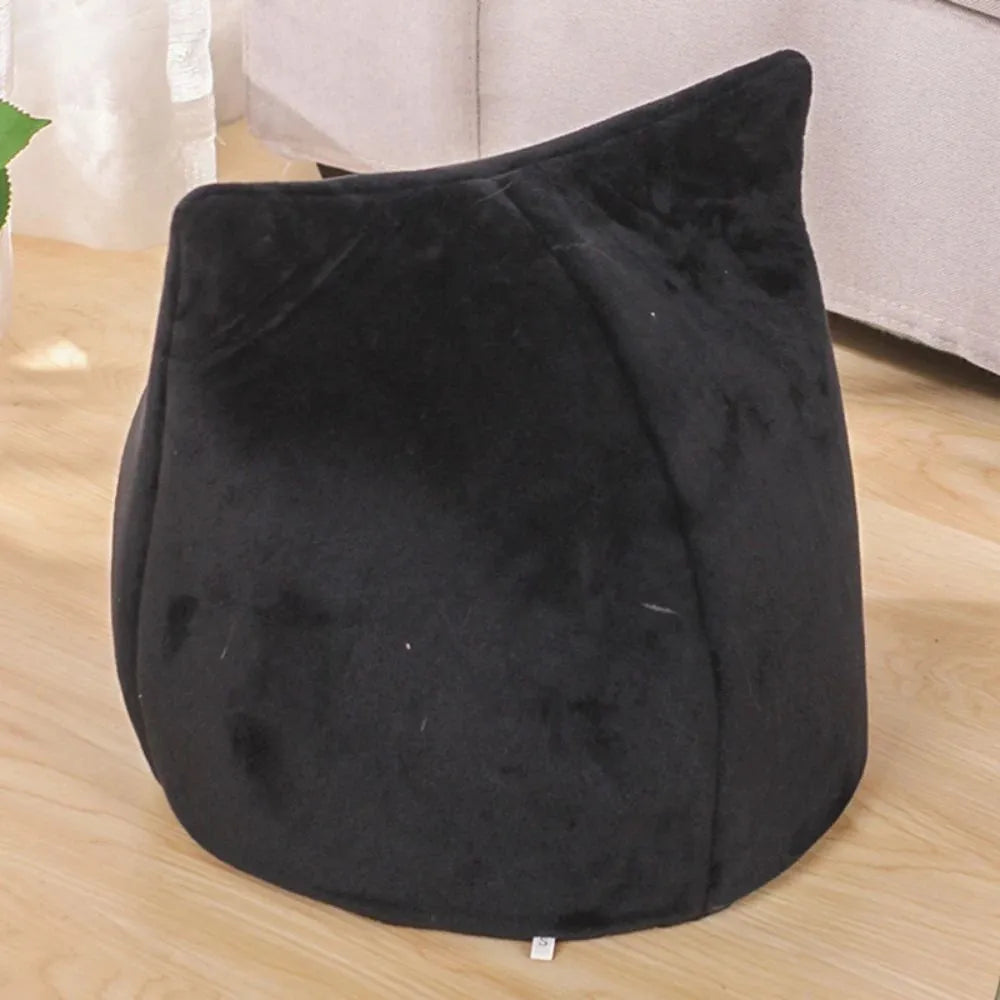 Grey cat-shaped enclosed pet bed with a round opening, sitting on a wooden floor.