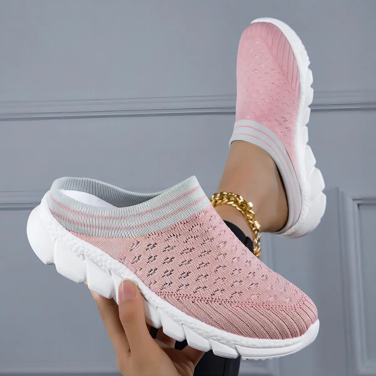 Women's black Flyknit semi-slipper casual shoe with striped pattern and hollow-out design on a white background.
