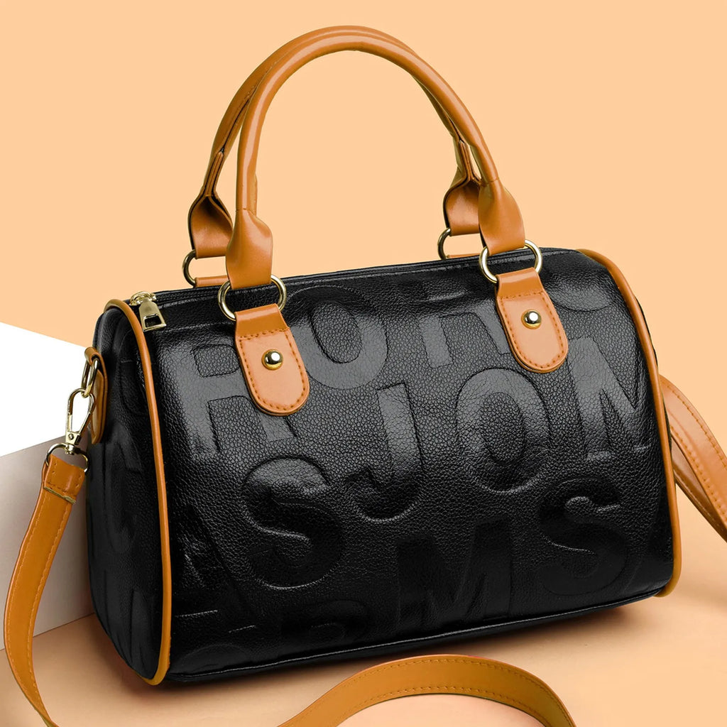Cylindrical crossbody bag in brown PU leather with three shoulder straps showing textured exterior