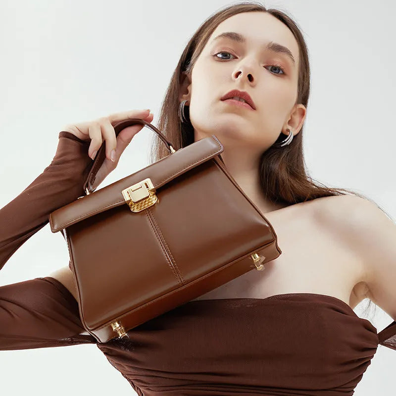 Women's black genuine vachette leather shoulder bag with clasp closure and 120cm strap.