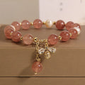 Women's bracelet with strawberry quartz beads, three freshwater pearls, and sparkling zircon details on a metal chain.