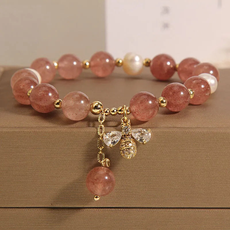 Women's bracelet with strawberry quartz beads, three freshwater pearls, and sparkling zircon details on a metal chain.