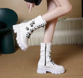 A pair of black women's mid-calf boots with a side zip and a round toe, showing the metal buckle detail.