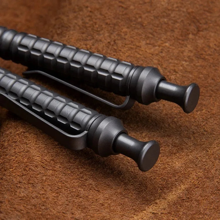 Gunmetal grey titanium alloy tactical pen with push-action mechanism and 0.5mm nib in a gift box.