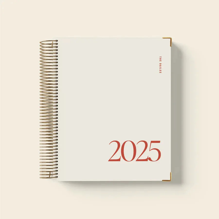 Cherry red daily schedule coil notebook with wire-o binding open on desk