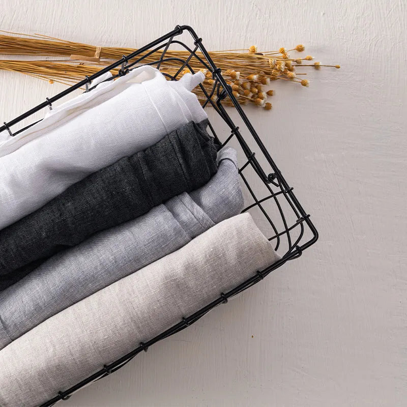 Men's straight leg linen trousers in light grey on a hanger.