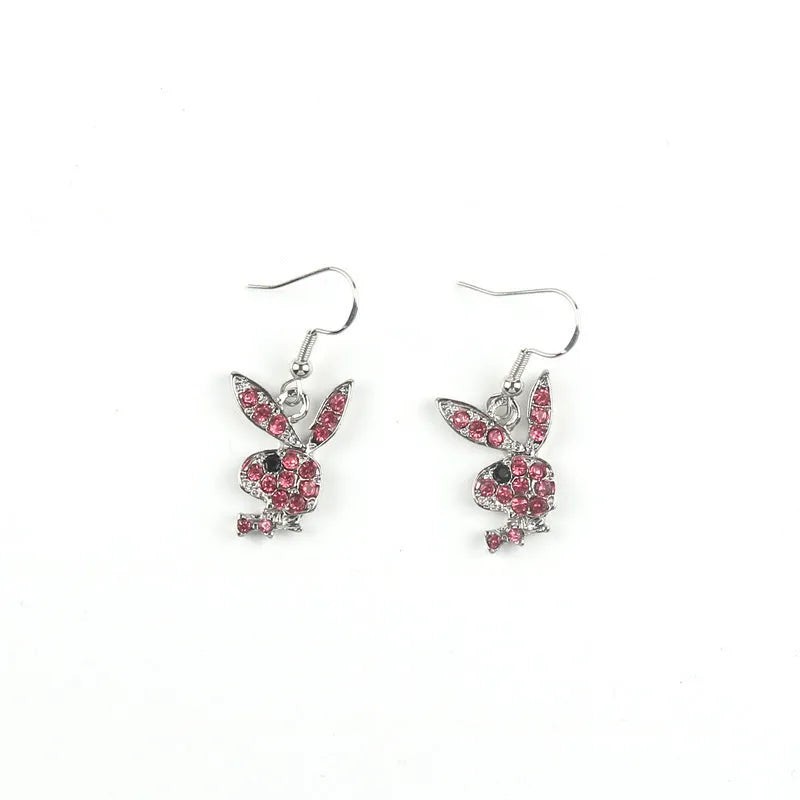 Close-up of a pair of small silver rabbit stud earrings with a sparkling rhinestone set in the centre on a white background.