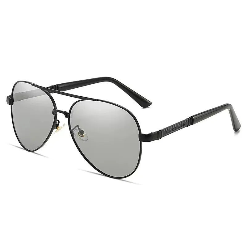 Gold metal frame sunglasses with polarised grey lenses and dragon phoenix temple detail on a table.