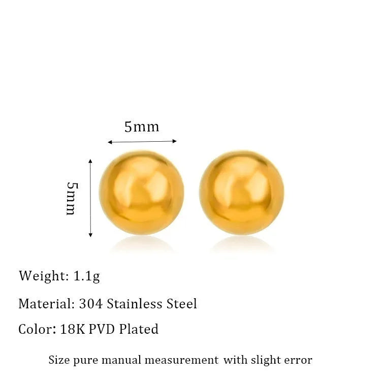 Close-up of minimalist round ball stud earrings in gold and silver finishes on a neutral background.